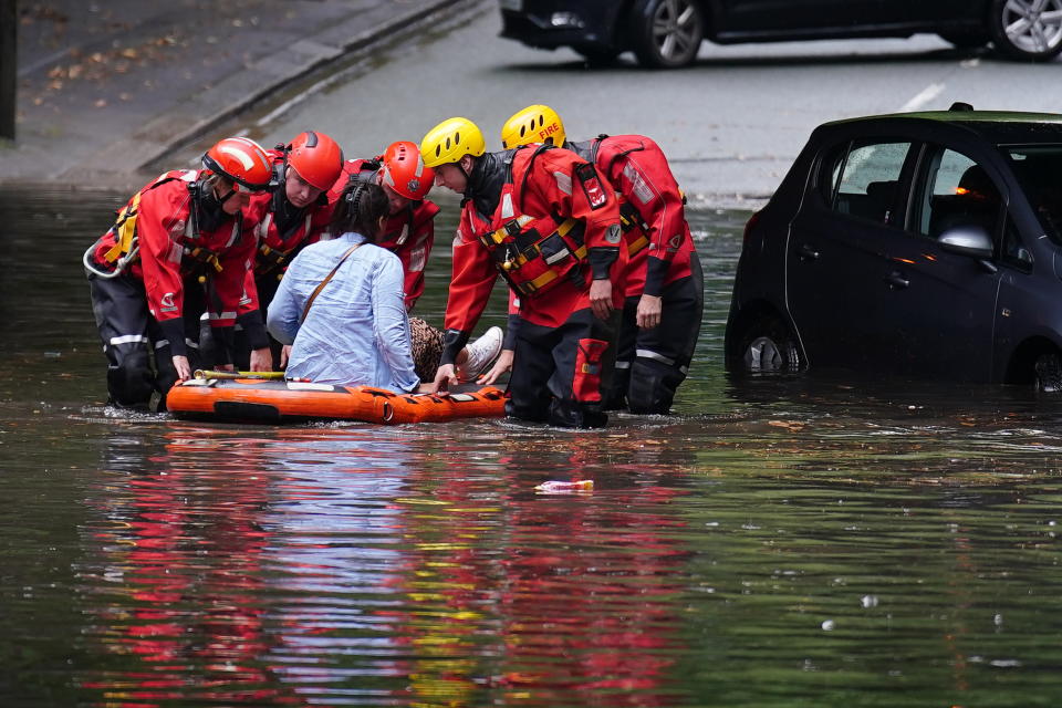 Emergency services rescue a woman from her vehicle after it got stranded on a flooded road in Mossley Hill, Liverpool. Picture date: Saturday July 8, 2023. The UK is facing thunderstorms and heavy rain as forecasts that the country could see the hottest of the year were changed. (Photo by Peter Byrne/PA Images via Getty Images)