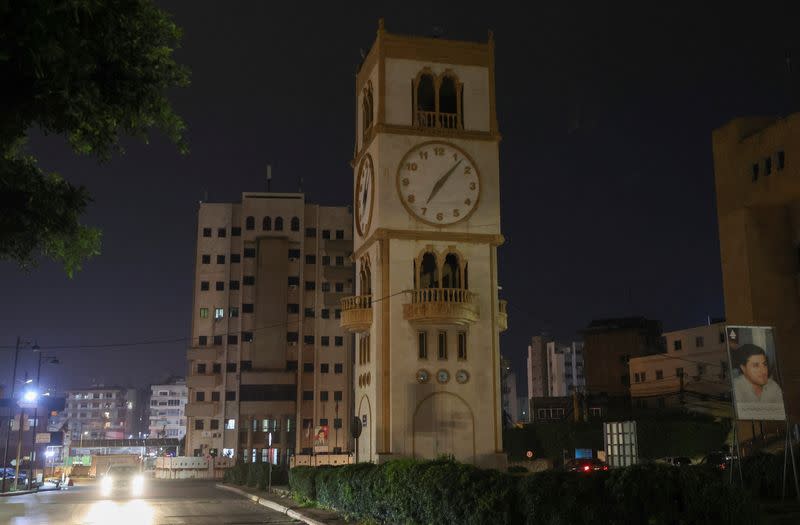 A car drives near a clock tower in Jdeideh