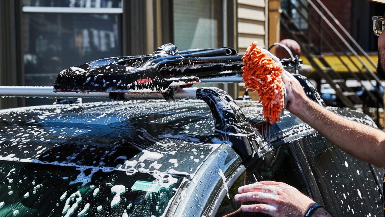 a person spraying water on a car