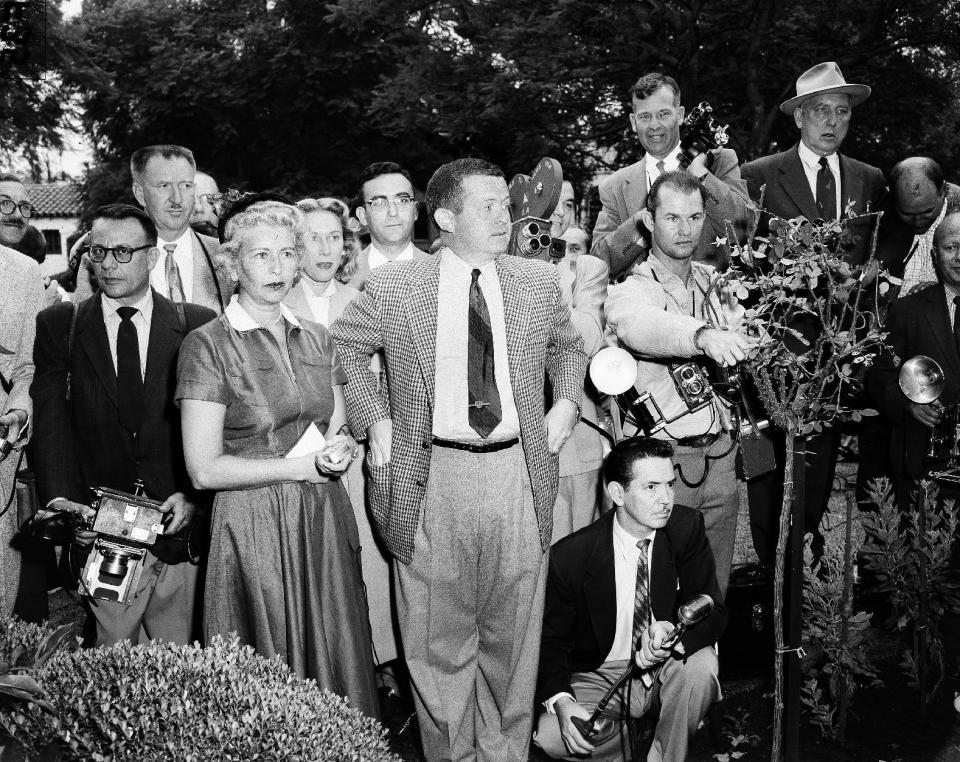 In this Oct. 6, 1954 file photo, Associated Press reporter Bob Thomas, center, and other media wait outside the Beverly Hills house of Marilyn Monroe, after reports that the movie star's marriage to baseball star Joe DiMaggio was breaking up. Thomas, the longtime Associated Press reporter who kept the world informed on the comings and goings of Hollywood's biggest stars, died of age-related illnesses Friday, March 14, 2014 at his Encino, Calif., home, his daughter Janet Thomas said. He was 92. (AP Photo)