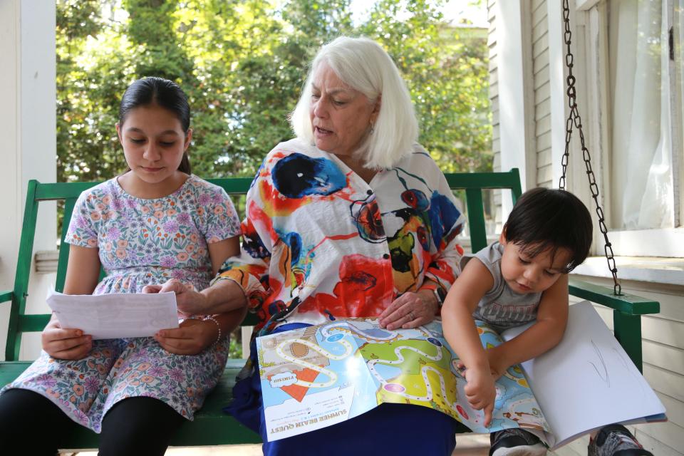 Retired teacher Sissy Hoffman works with Farahnaz, left, and Noman on their English. The children left Afghanistan in September of last year and relocated to Savannah.