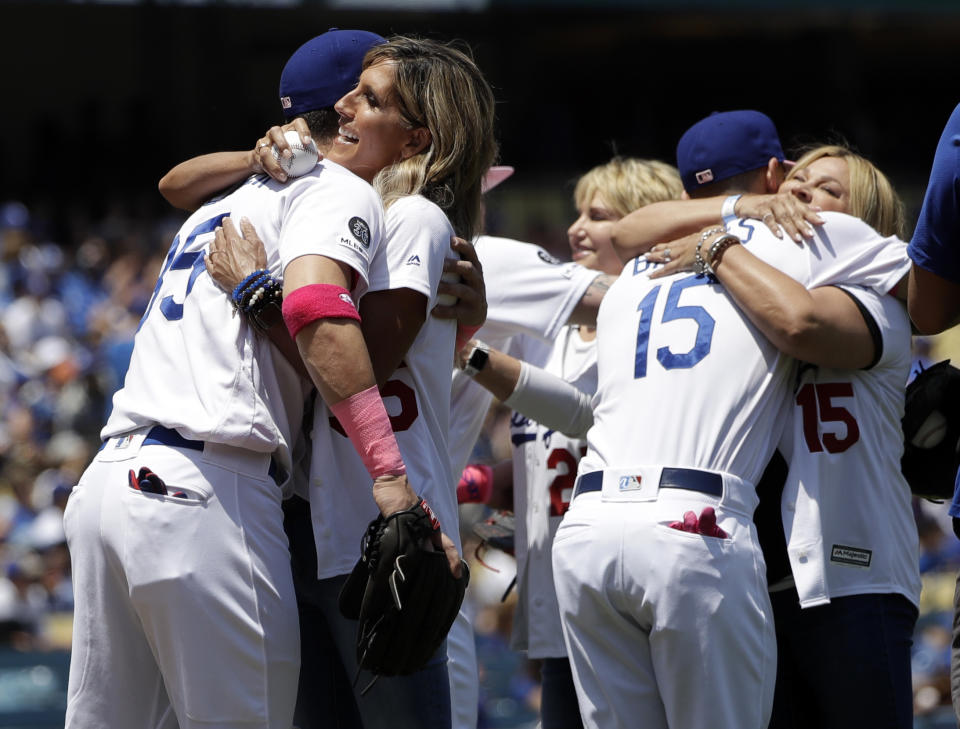 Los Angeles Dodgers' Cody Bellinger, left, hugs his mother Jennifer and Austin Barnes (15) hugs his mother Stephanie after the mothers threw ceremonial first pitches before a baseball game against the Washington Nationals, Sunday, May 12, 2019, in Los Angeles. (AP Photo/Marcio Jose Sanchez)