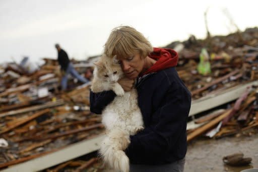 Las familias de la localidad estadounidense de Moore, en Oklahoma, volvían (las que podían) a sus casas para ver el destrozo del tornado sobre ellas. El tornado dejó el lunes al menos 24 muertos, nueve de ellos niños, y toda la ciudad devastada. (AFP | Joshua Lott)