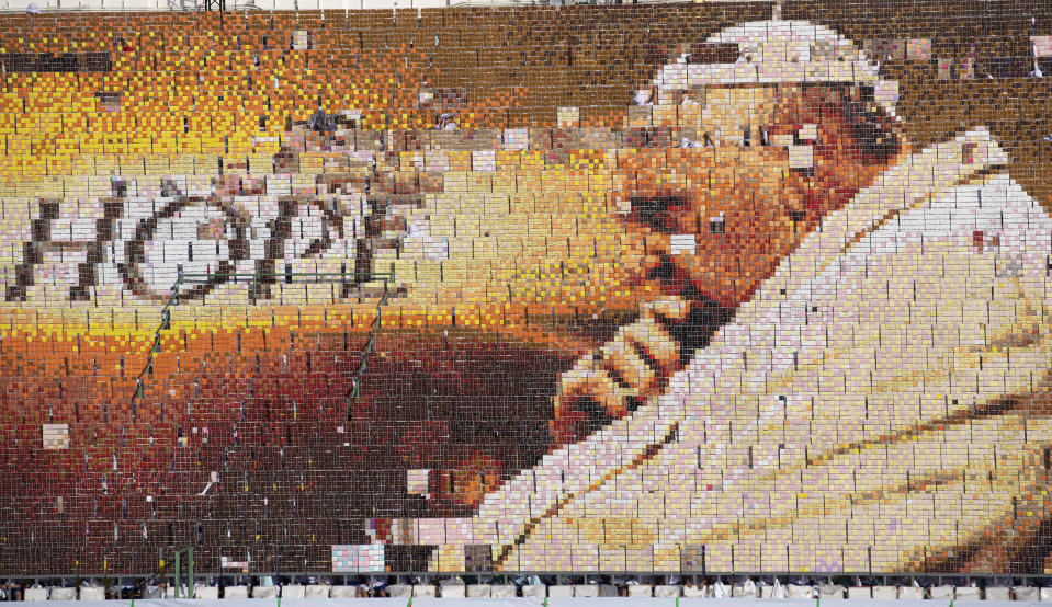 Students practice flipping boards with photos to reveal a full-mosaic portrait of Pope Francis before a Holy Mass at National Stadium in Bangkok, Thailand, Thursday, Nov. 21, 2019. (AP Photo/Sakchai Lalit)