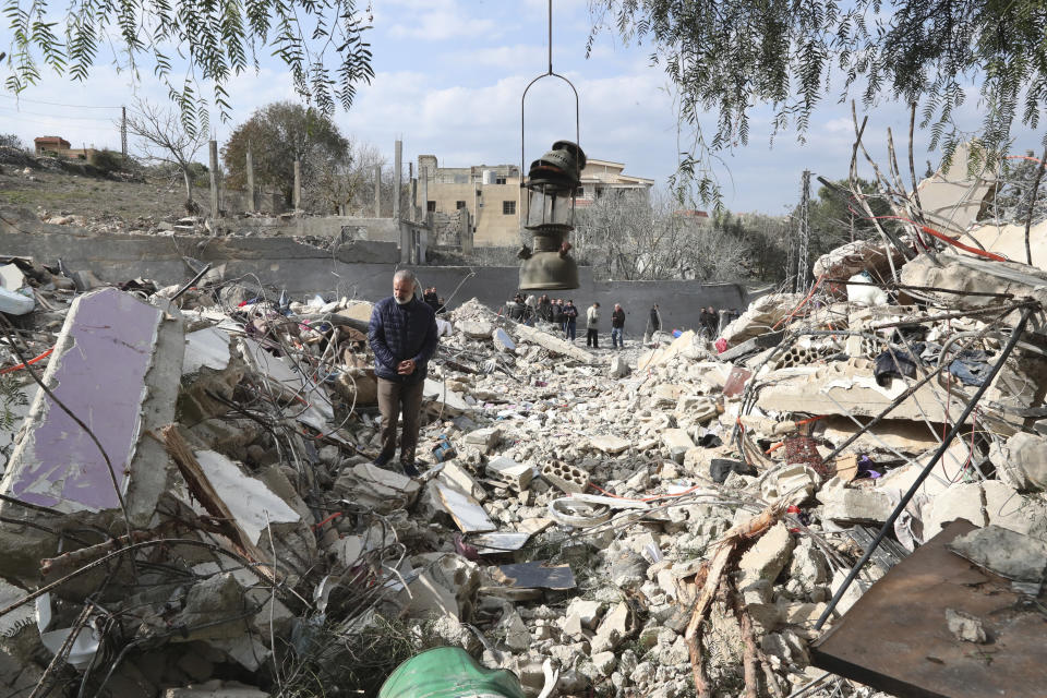 A Lebanese man stands on the rubbles of a house that was destroyed by an Israeli airstrike Tuesday night, in Bint Jbeil, South Lebanon, Wednesday, Dec. 27, 2023. One Hezbollah fighter and two civilians, a newlywed couple, were killed in an overnight Israeli strike on a family-owned residential building in the town of Bint Jbeil, local residents and state media said Wednesday. (AP Photo/Mohammed Zaatari)