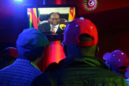 People watch as Zimbabwean President Robert Mugabe addresses the nation on television, at a bar in Harare, Zimbabwe, November 19, 2017. REUTERS/Philimon Bulawayo