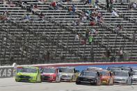 Todd Gilliland, left front, and Chase Elliott, right front, lead the field into the front stretch coming out of Turn 4 during a NASCAR Truck Series auto race at Texas Motor Speedway in Fort Worth, Texas, Saturday, June 12, 2021. (AP Photo/Larry Papke)