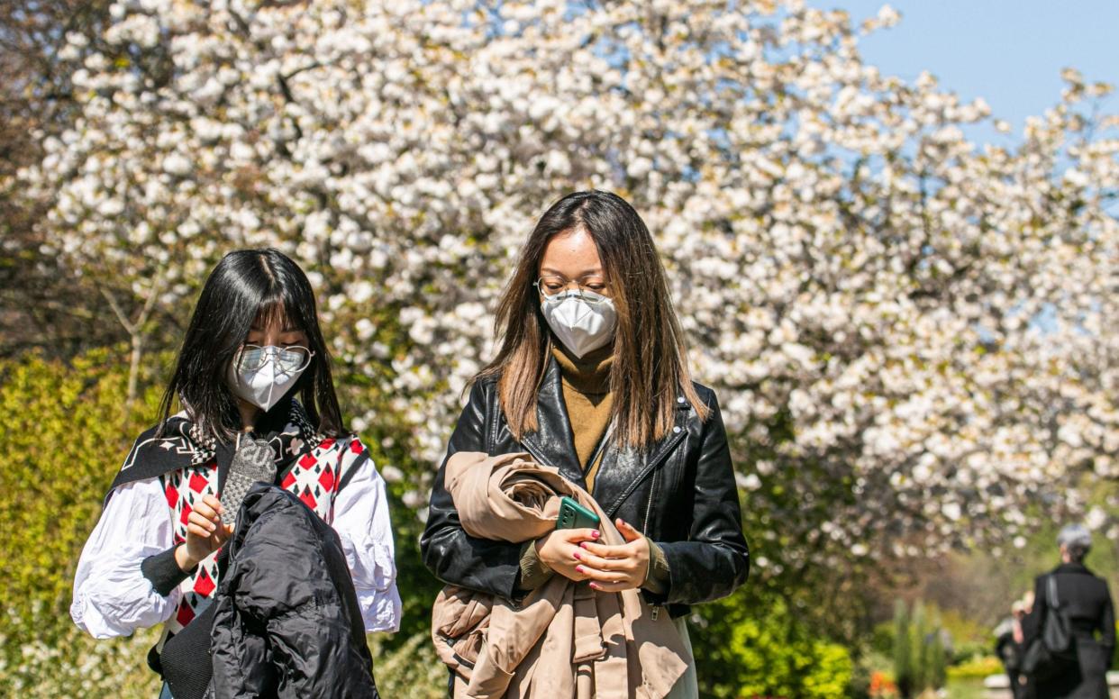 People out in the warm spring sunshine on Regents Park, London  - Shutterstock