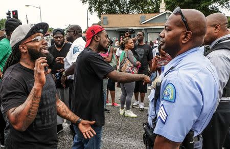 Area residents talk to police after a shooting incident in St. Louis, Missouri August 19, 2015. REUTERS/Lawrence Bryant
