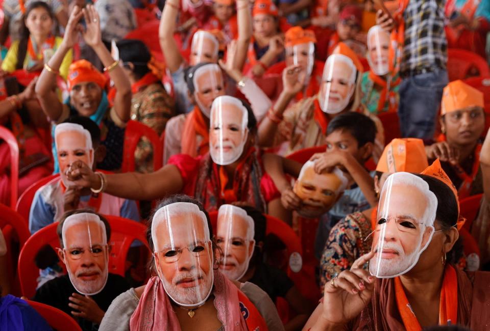 Supporters of Narendra Modi’s BJP wearing masks of his face at an election rally in Meerut on Sunday (REUTERS)