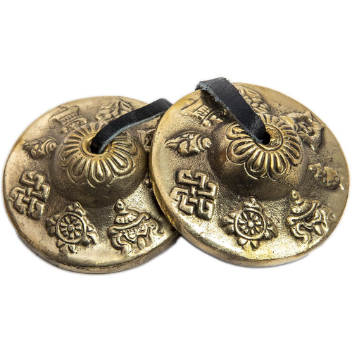 two gold himalayan bazaar tingsha cymbals against white background