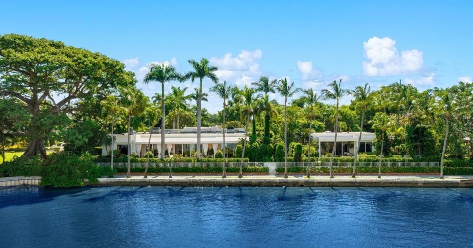 Just listed at $59.5 million, a lakefront estate at 315 Chapel Hill Road in Palm Beach includes the main house at the left and the guesthouse at the right. The famous kapok tree on the grounds of the Royal Poinciana Chapel can be seen at the far left.