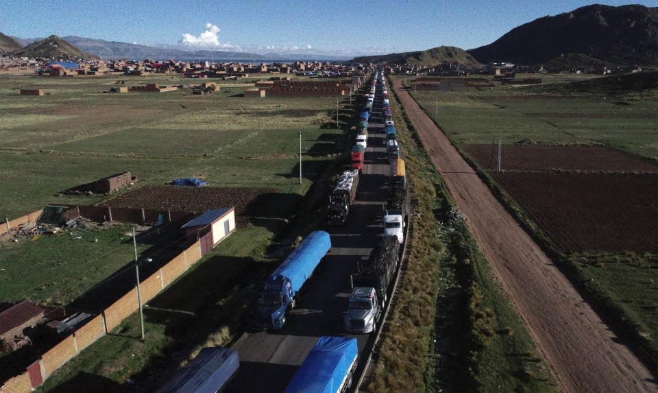 Cargo trucks are backed up in Desaguadero, Bolivia, on the border with Peru, unable to cross to Peru due to roadblocks by anti-government protests in Peru, Friday, Jan. 13, 2023. (AP Photo/Juan Karita)