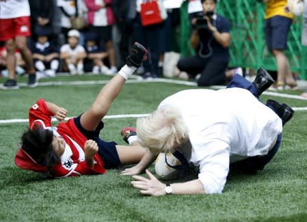 London's Mayor Boris Johnson falls down after colliding with 10-year-old Toki Sekiguchi in Tokyo