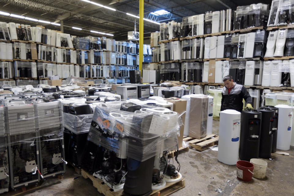In this May 7, 2019 photo, water coolers are stacked and ready to be broken down into parts for recycling at a GDB International warehouse in Monmouth Junction, N.J. China’s decision to restrict scrap imports created big challenges for U.S. recycling programs last year. But it has also spurred investment in plants that process recyclables no longer being shipped overseas. (AP Photo/Seth Wenig)