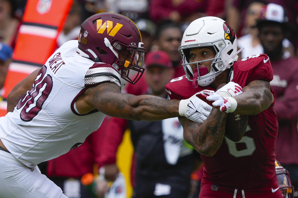 Arizona Cardinals running back James Conner (6) goes around Washington Commanders defensive end Montez Sweat (90) during the first half of an NFL football game, Sunday, Sept. 10, 2023, in Landover, Md. (AP Photo/Susan Walsh)