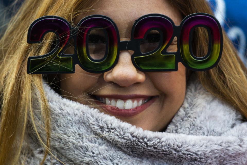 A woman wears glasses as she waits to celebrate New Years Eve in Times Square on Dec. 31, 2019 in New York City. Because of the mild weather, a larger than usual crowd of people visiting from all over the world is expected to watch the ball drop. 