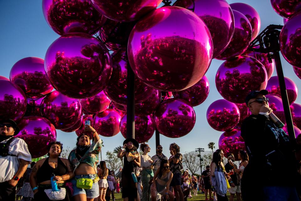 Festivalgoers take shade and walk through 'Molecula Cloud' by Vincent Leroy during the Coachella Valley Music and Arts Festival at the Empire Polo Club in Indio, Calif., Friday, April 14, 2023.