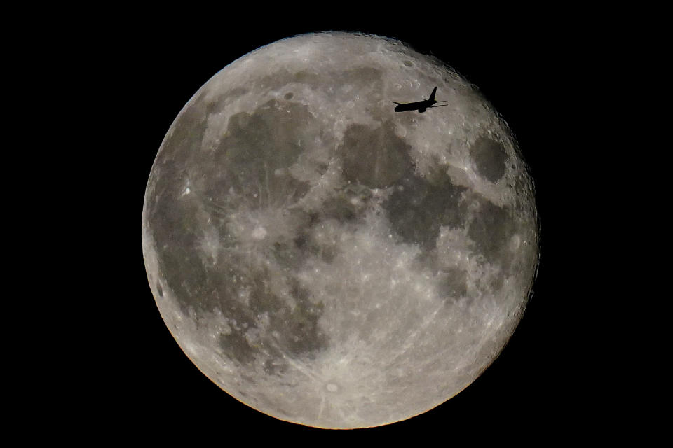 A plane passes in front of the Sturgeon supermoon, the final supermoon of the year, over east London. Picture date: Friday August 12, 2022. (Photo by Victoria Jones/PA Images via Getty Images)