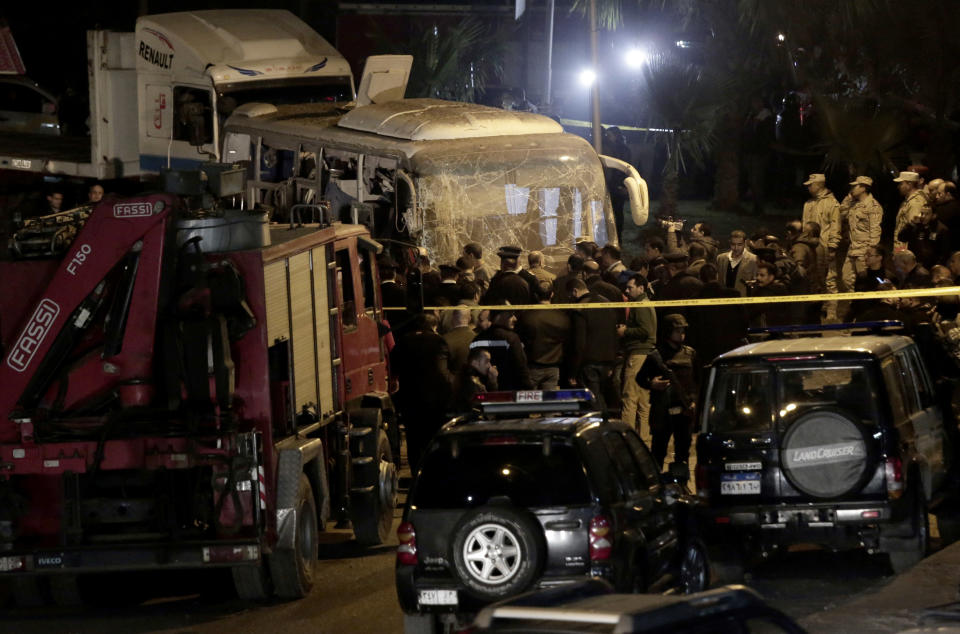 Security forces stand near a tourist bus after a roadside bomb in an area near the Giza Pyramids in Cairo, Egypt. Egypt's Interior Ministry said in a statement that two Vietnamese tourists were killed and others wounded, in the incident. (AP Photo/Nariman El-Mofty)