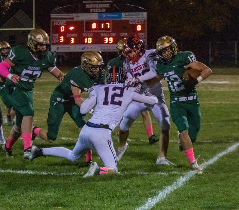 Patrick Lipford of St. Mary Catholic Central goes around the edge to avoid Grosse Pointe Woods University Liggett's Jack Jones (12) and Alex Gould (20) while Cole Jondro (11) and Blake Philbeck (57) block Friday night. SMCC won the Division 7 playoff game 41-0.