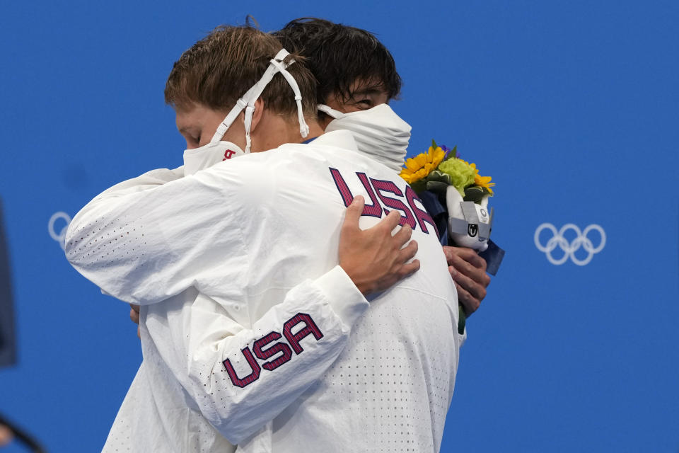 Gold medalist Chase Kalisz, left, of the United States, embraces teammate and silver medalist Jay Litherland, during the medal ceremony for the the men's 400-meter individual medley at the 2020 Summer Olympics, Sunday, July 25, 2021, in Tokyo, Japan. (AP Photo/Martin Meissner)