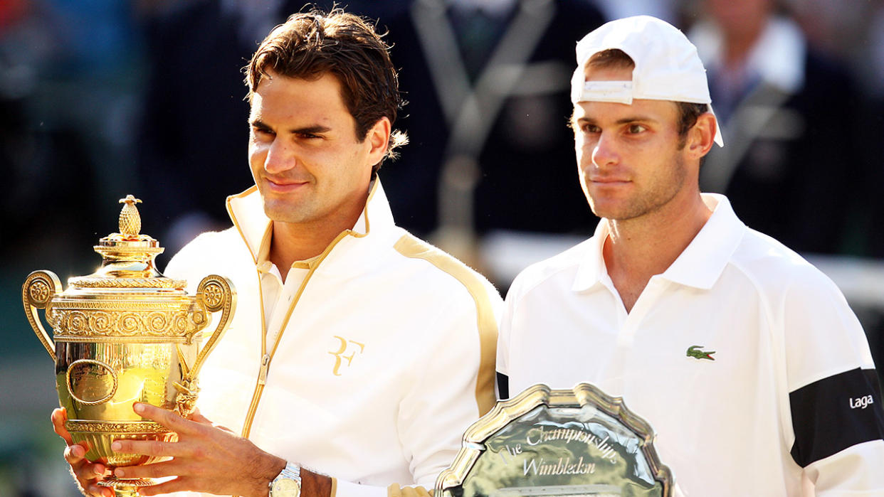 Roger Federer (pictured left) holding up the trophy next to Andy Roddick (pictured right) at Wimbledon.