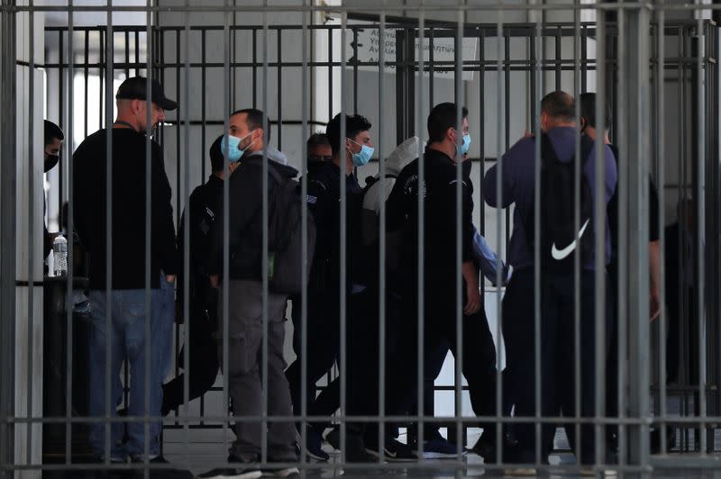 Agentes de policía trasladan a los acusados tras ser detenidos tras el fin del juicio de líderes y miembros del partido de extrema derecha Amanecer Dorado, que fue declarado organización criminal por un tribunal, en Atenas, Grecia