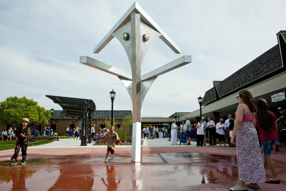 Kids play in the water falling from the fountain during the grand opening of the Riverview Plaza courtyard Thursday, June 18, 2015 in St. Clair.