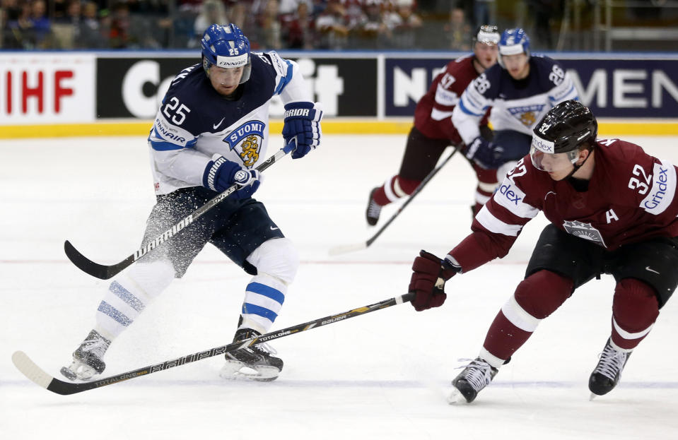Finland forward Pekka Jormakka, left, is challenged by Latvia defender Arturs Kulda during the Group B preliminary round match between Finland and Latvia at the Ice Hockey World Championship in Minsk, Belarus, Saturday, May 10, 2014. (AP Photo/Darko Bandic)