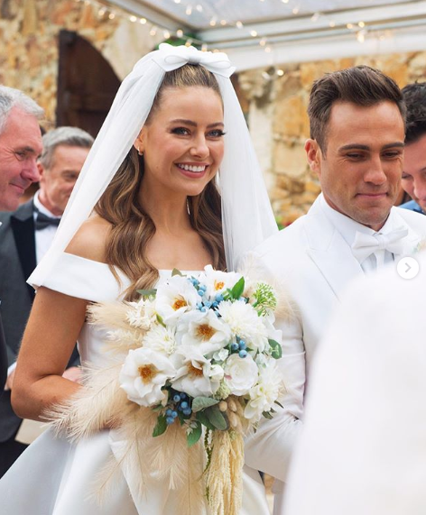 A photo of April Rose Pengilly wearing a white wedding dress and veil on set of her TV wedding on Neighbours.