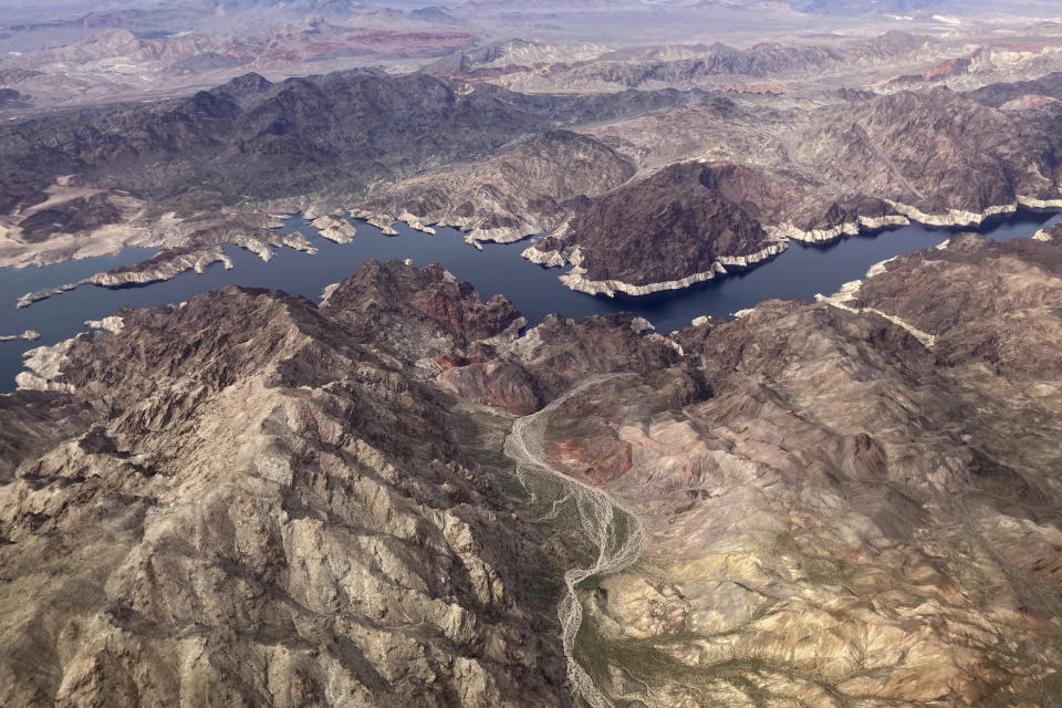 In this aerial photo, a bathtub ring of light minerals show the high water mark on the shore of Lake Mead along the border of Nevada and Arizona, Monday, March 6, 2023, near Boulder City, Nev. Record snowfall and rain have helped to loosen drought’s grip on parts of the western U.S. as national forecasters and climate experts warned Thursday, March 16, that some areas should expect more flooding as the snow begins to melt. Groundwater and reservoir storage levels — which take much longer to bounce back — remain at historic lows. (AP Photo/John Locher)