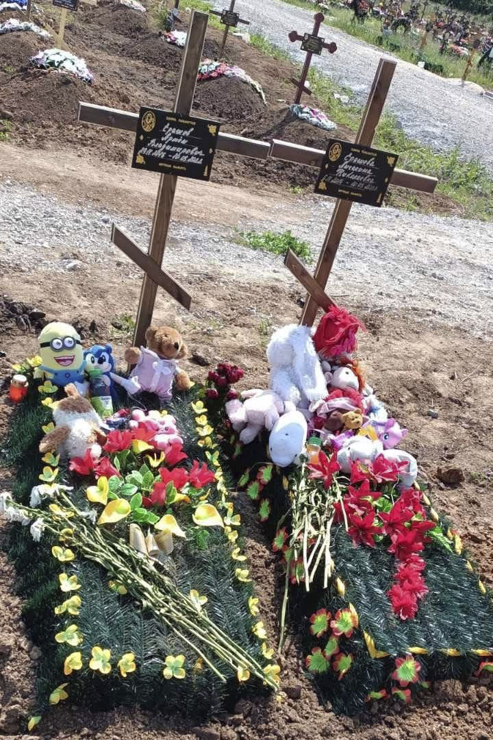 This photo provided by the family shows the graves of two young cousins, Artem and Angelina Erashov, who were killed in Mariupol, Ukraine, during Russian shelling on March 9, 2022. Their parents fled Mariupol soon after but returned to the occupied city in July to rebury the children, ages 5 and 7, in the Staryi Krym cemetery, now the site of thousands of new graves since the Russian invasion began Feb. 24. (Family photo via AP)