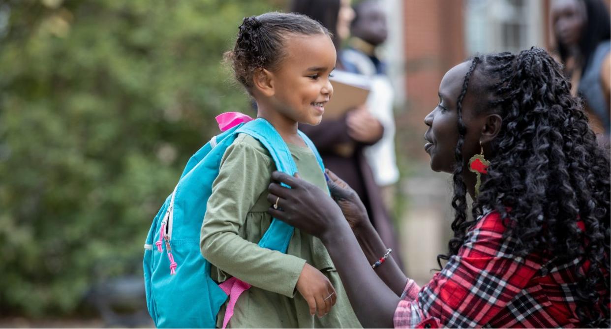 Parent saying goodbye to child on first day of school. (Getty Images)