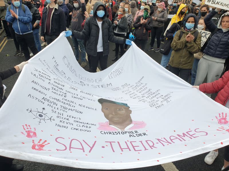 Demonstrators hold a banner during a Black Lives Matter protest in Parliament Square, following the death of George Floyd who died in police custody in Minneapolis, in London