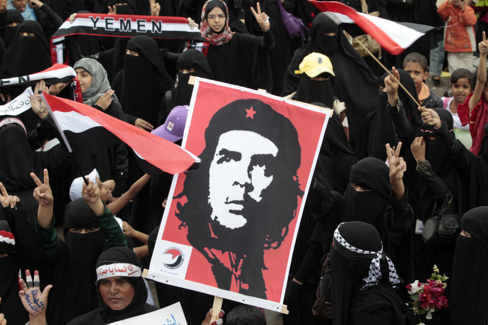 Anti-government protesters chant slogans as they wave Yemeni flags and a poster of Cuban revolution leader Che Guevara during a rally to demand the ouster of President Ali Abdullah Saleh in Sanaa September 26, 2011. REUTERS/Ahmed Jadallah (YEMEN - Tags: POLITICS CIVIL UNREST)