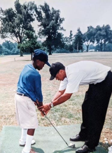 In this 1997 photo, a young J.P. Thornton receives instructions from Tiger Woods during the Tiger Woods Foundation Junior Golf Clinic and Exhibition at Pine Hill Golf Course in Memphis.