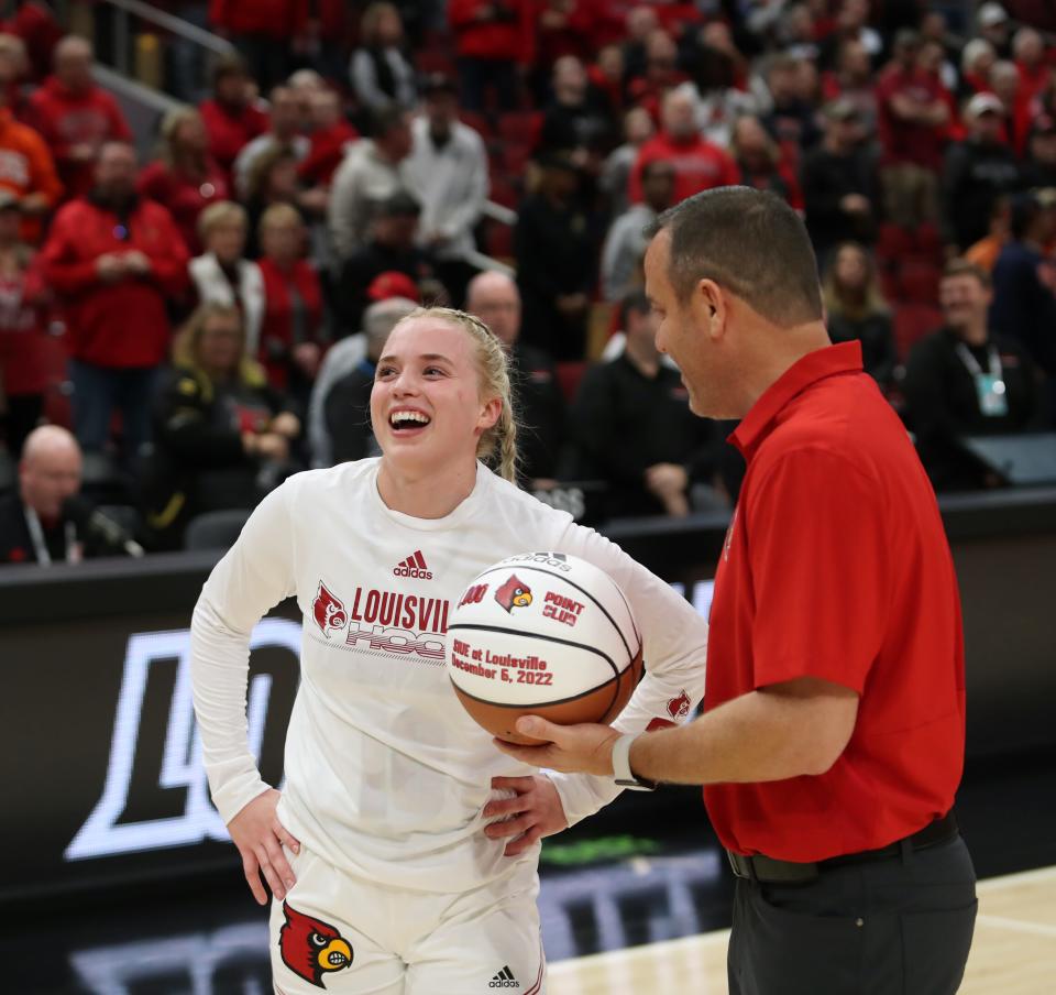 Louisville’s Hailey Van Lith is given her 1,000 point ball from coach Jeff Walz.Dec. 29, 2022