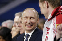 Russian President Vladimir Putin (L) laughs with Russia's gold medallist bobsleigh athlete Alexander Zubkov during the closing ceremony for the 2014 Sochi Winter Olympics, February 23, 2014. REUTERS/David Goldman/Pool (RUSSIA - Tags: OLYMPICS SPORT POLITICS SPORT BOBSLEIGH)