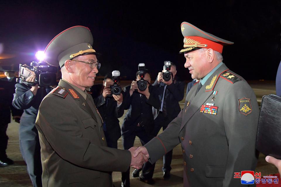 Russian defence minister Sergei Shoigu, right, is welcomed by North Korean defence minister Kang Sun Nam at Pyongyang International Airport in Pyongyang on Tuesday (AP)