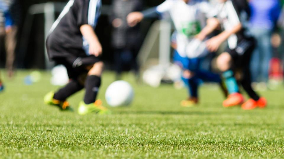 Picture of kids soccer training match with shallow depth of field. Focus on foreground.