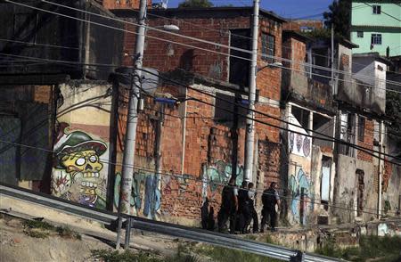 Police officers from the Pacifying Police Unit (UPP) patrol the streets at the Complexo do Alemao slum in Rio de Janeiro March 15, 2014. REUTERS/Pilar Olivares