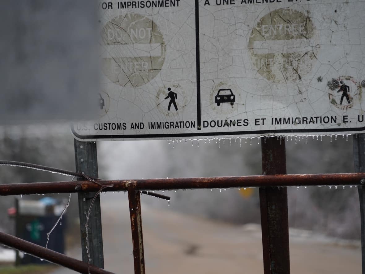 Freezing rain clings to a 'do not enter' sign at Roxham Road on Jan. 5, 2022. Migrants are being bused near the area from New York City. (Charles Contant/CBC - image credit)