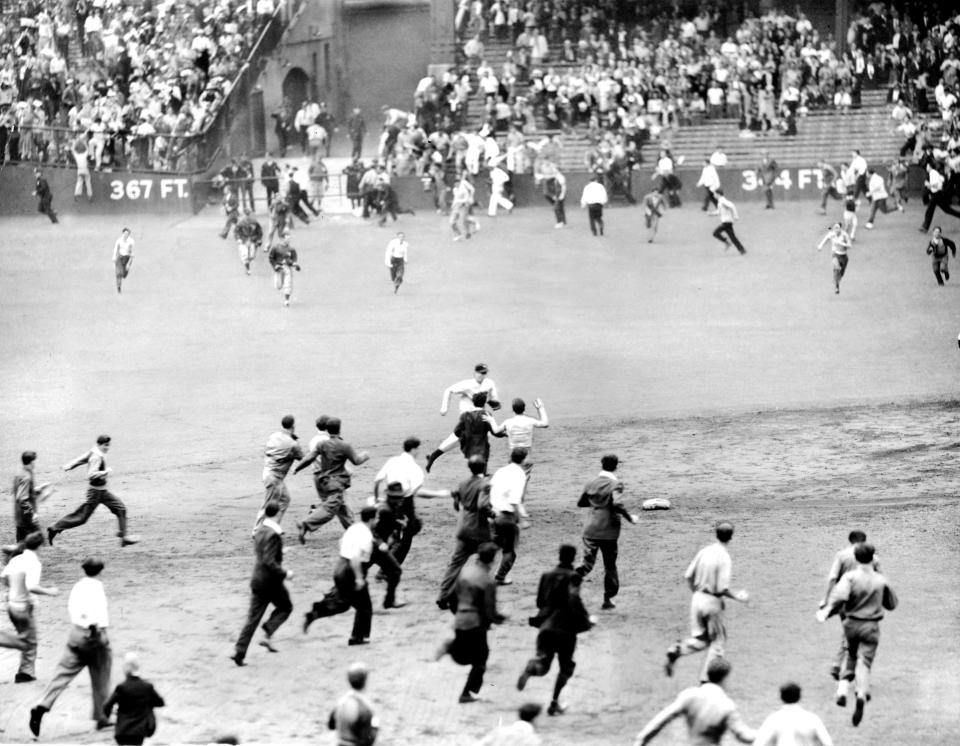 New York Yankees Joe DiMaggio pays the price of idolatry as enthusiastic fans run at him from all sides after last out at Yankee Stadium. Joe ran hitting streak to 48 consecutive games. Yanks took two., No sales, no archiving, no website usage., (Photo by NY Daily News Archive via Getty Images)