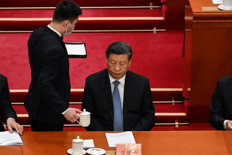 Un asistente sirve té al presidente chino Xi Jinping (C) durante la ceremonia de apertura de la Conferencia Consultiva Política del Pueblo Chino (CCPPC) en el Gran Salón del Pueblo en Pekín el 4 de marzo de 2023.