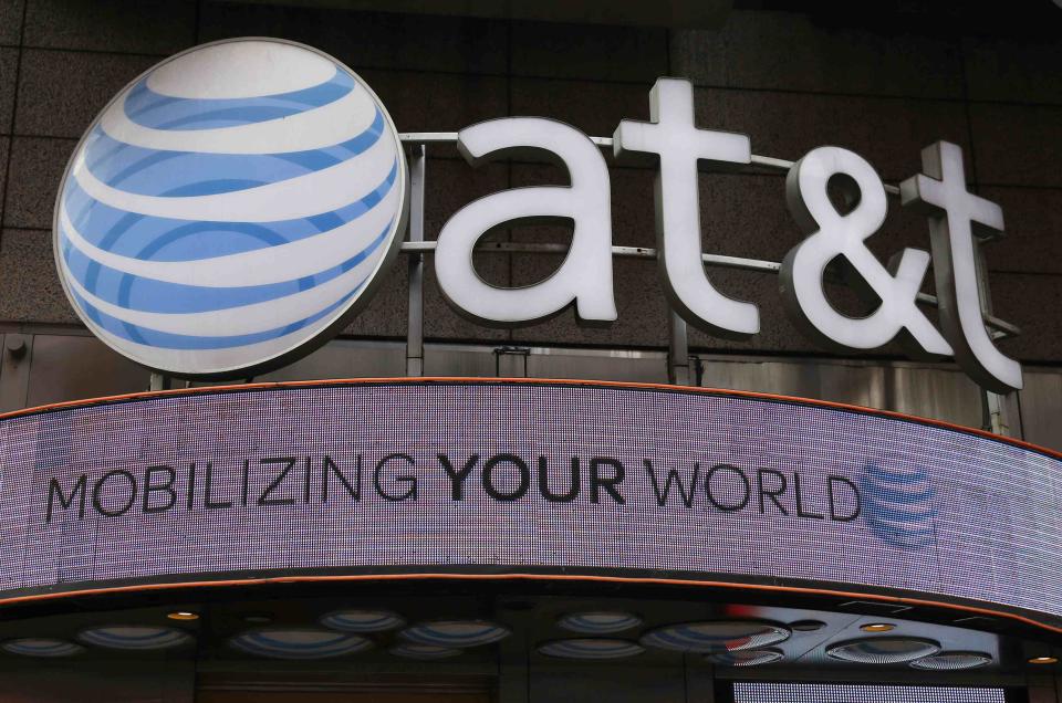 The signage for an AT&T store is seen in New York in this file photo taken October 29, 2014. AT&T will pause investments to bring fiber connections to 100 cities until U.S. regulators iron out rules to regulate how Internet service providers manage their Web traffic, the company's chief executive told investors at a conference on Wednesday. REUTERS/Shannon Stapleton/Files (UNITED STATES - Tags: BUSINESS LOGO TELECOMS)