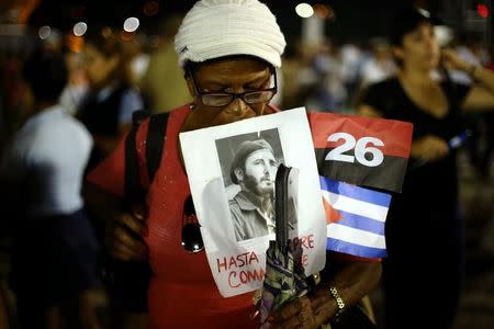 A woman holds an image of former Cuban leader Fidel Castro at a tribute to Castro in Santiago de Cuba, Cuba, December 3, 2016. REUTERS/Ivan Alvarado