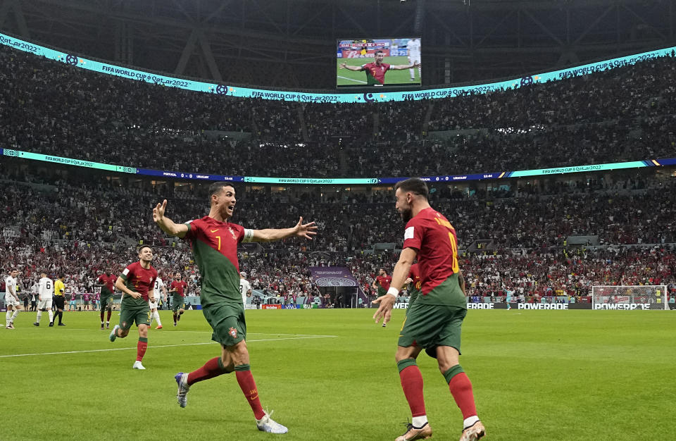 Portugal's Cristiano Ronaldo celebrates his side's opening goal with Portugal's Bruno Fernandes during the World Cup group H soccer match between Portugal and Uruguay, at the Lusail Stadium in Lusail, Qatar, Monday, Nov. 28, 2022. (AP Photo/Themba Hadebe)