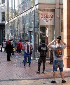 <span class="caption">The revenues of the UK’s nine leading supermarkets have skyrocketed during the pandemic.</span> <span class="attribution"><a class="link " href="https://www.shutterstock.com/image-photo/birmingham-uk-2020-long-queue-people-1705791268" rel="nofollow noopener" target="_blank" data-ylk="slk:UAV 4/Shutterstock;elm:context_link;itc:0;sec:content-canvas">UAV 4/Shutterstock</a></span>