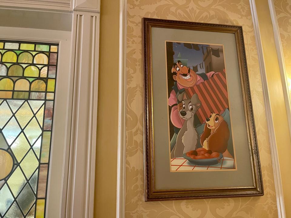 stained glass window and photo from lady and the tramp at tony's town square restaurant in magic kingdom at disney world